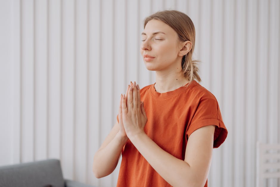 Calm woman in a seated yoga pose in a beautifully lit, serene room.